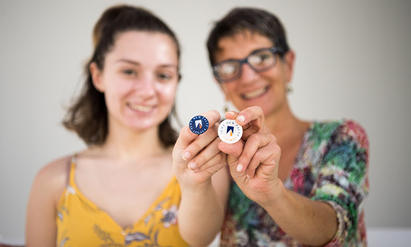 parent student holding alumni and legacy pins